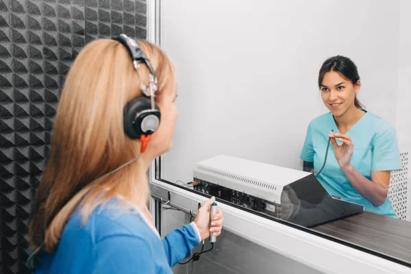 Audiologist conducting pure tone test on a patient