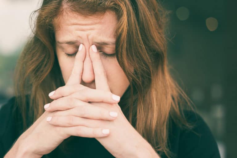 Woman holding her nasal ridge