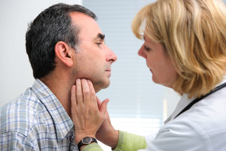 Doctor checking patients thyroids