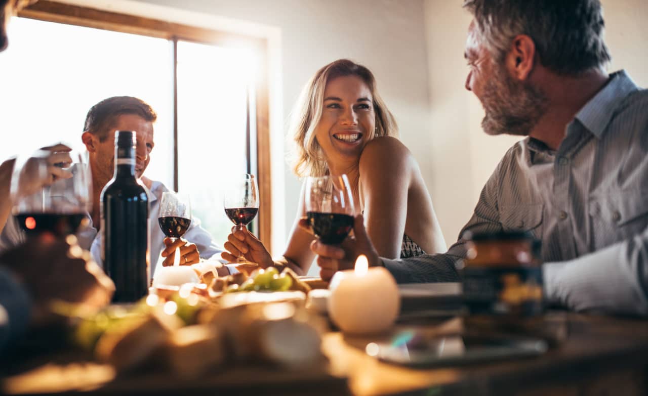 Two couples drinking wine around a table